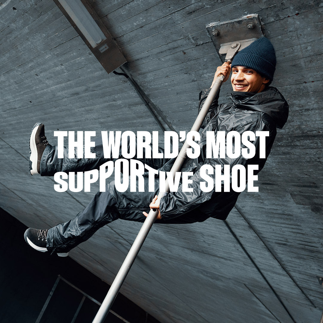 Mann med Kikut Lite fra Gaitline på føttene henger i stang og smiler