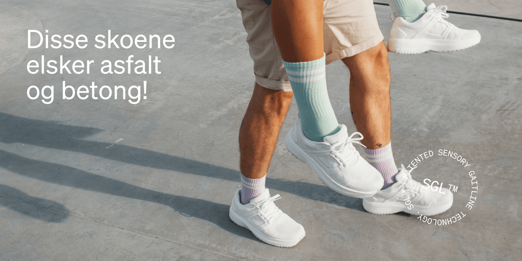 Par med hvite World Cup PRO sneakers fra Gaitline går på betong med fargerike sokker og tekst på bildet